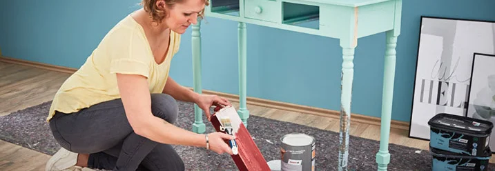 Person streicht einen Tisch an